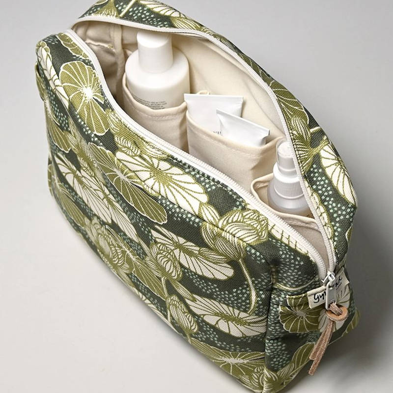 GYLLSTAD STUDIO Kosmetiktasche XL, Lotus, grün, aus Bio-Baumwolle. Offene Tasche mit Produkten.
