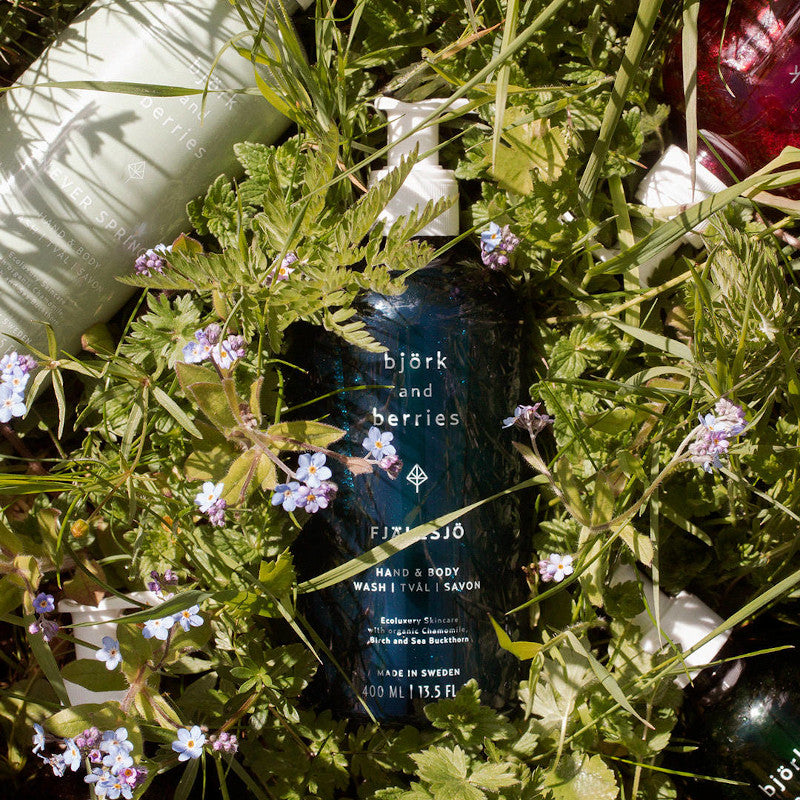 BJÖRK & BERRIES Fjällsjö Hand & Body Wash / Duschgel, bottle on flowers