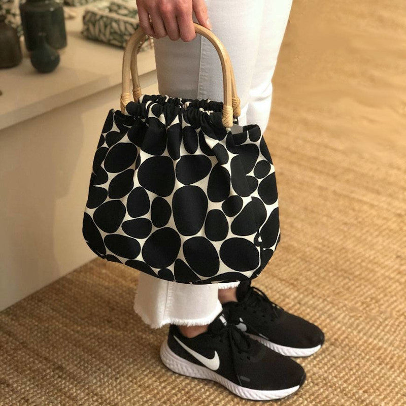 Frau hält GYLLSTAD STUDIO Handtasche Bambus, Stenar, schwarz & weiß