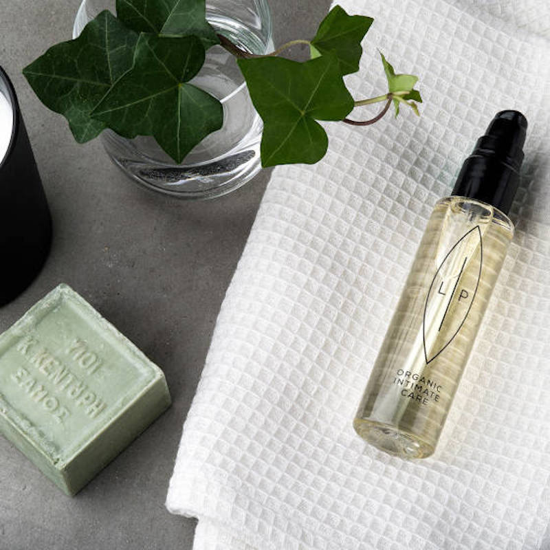 Lip Organic Intimate Care. Ölbasierte Produkte für den Intimbereich. Flasche auf einem Handuch.