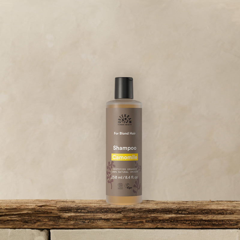URTEKRAM Shampoo for blonde hair, Camomile. Bottle on a bank.