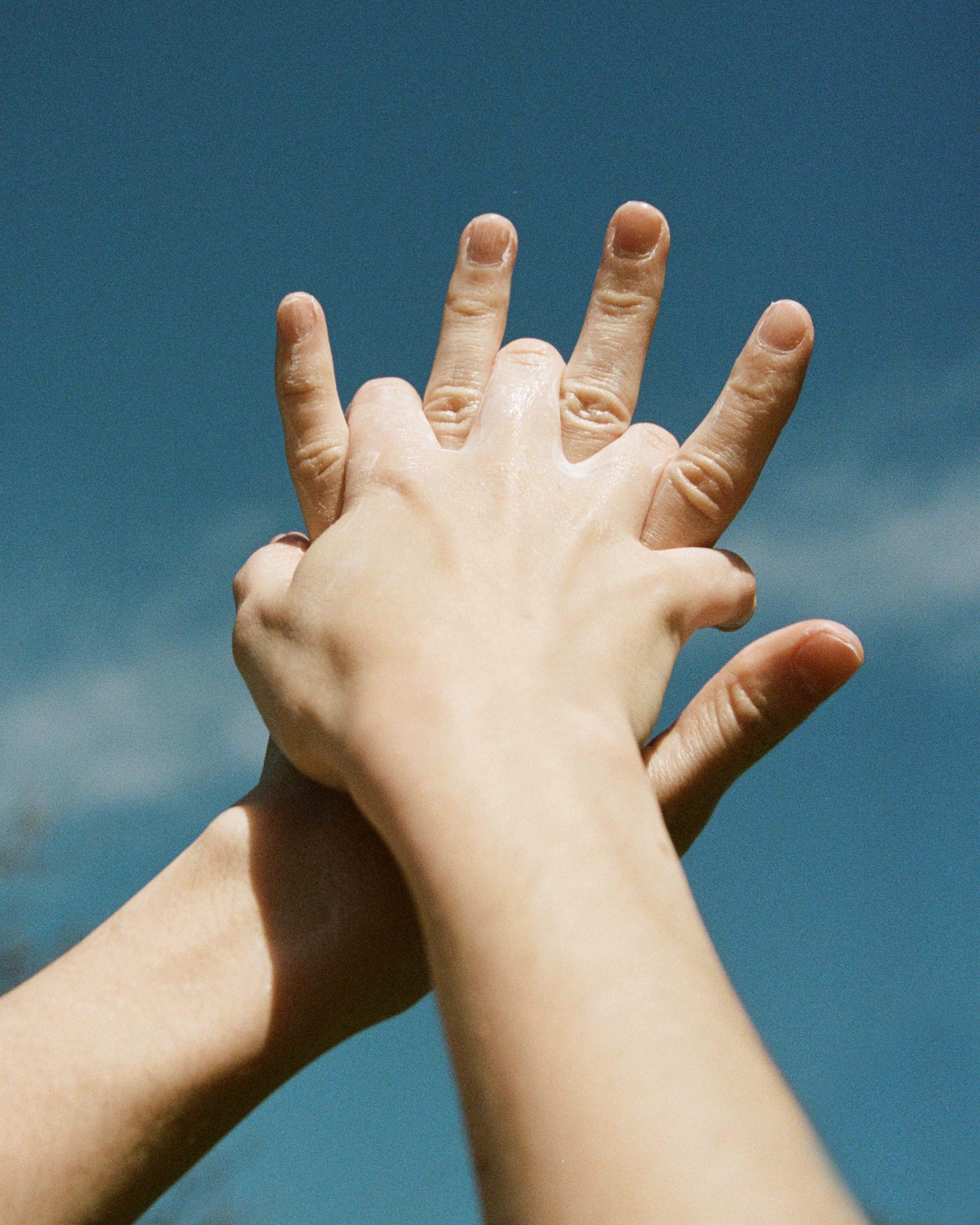 Hands towards a blue sky
