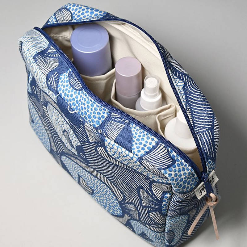 Gyllstad Studio. Kulturbeutel aus Bio-Baumwolle, offene Tasche mit Produkten
