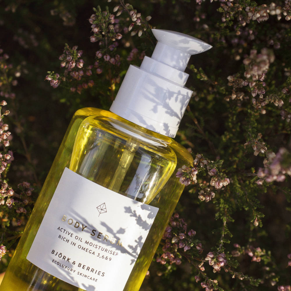 BJÖRK & BERRIES Body Serum / Körperserum, bottle laying on flowers