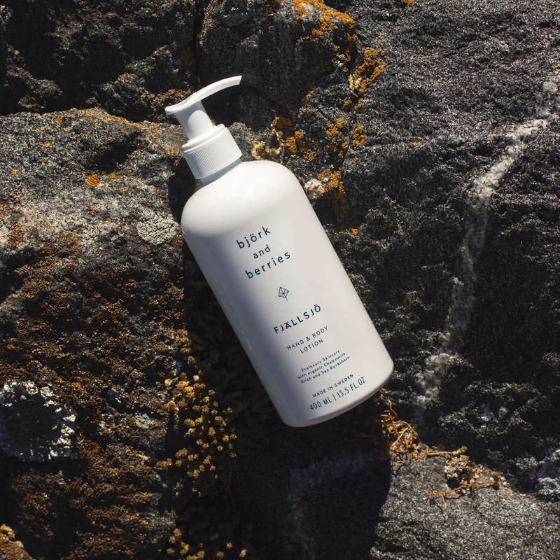 BJÖRK & BERRIES Fjällsjö Hand & Body Lotion, bottle on a cliff