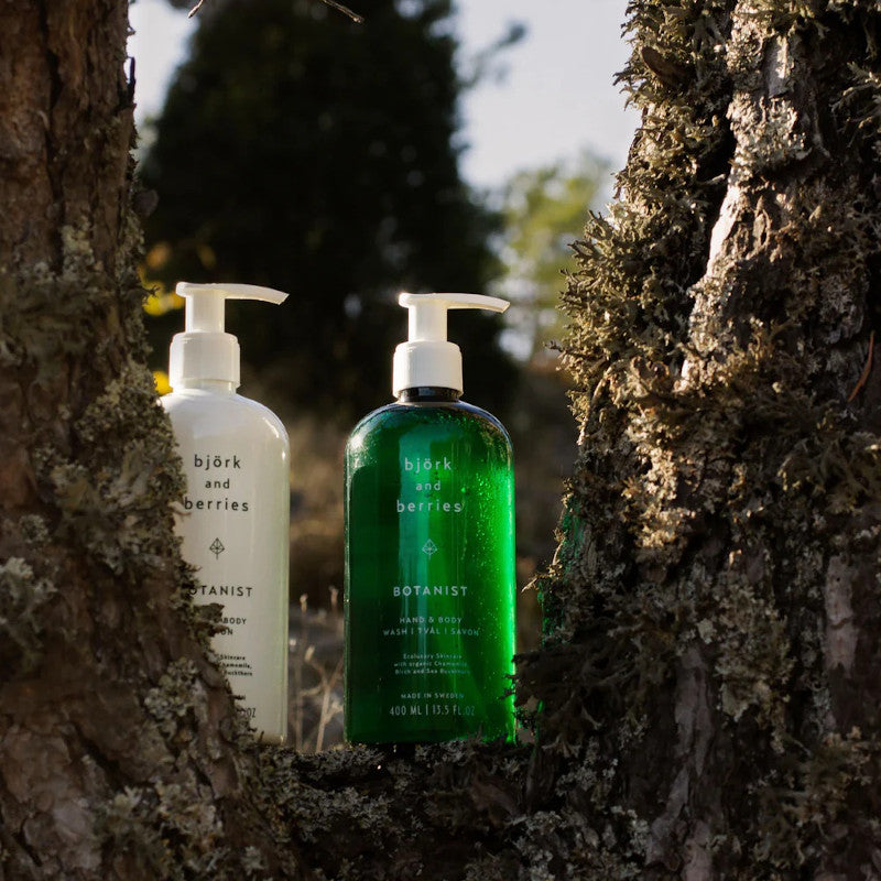 Björk & Berries Botanist Body Lotion & Soap. 2 bottles in a forest.