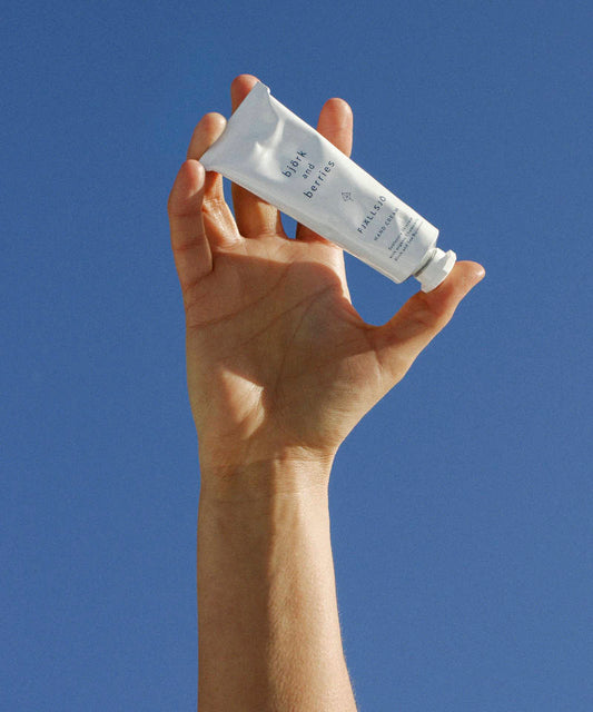 Björk & Berries Fjällsjö Handcreme. Hand hält Tube.