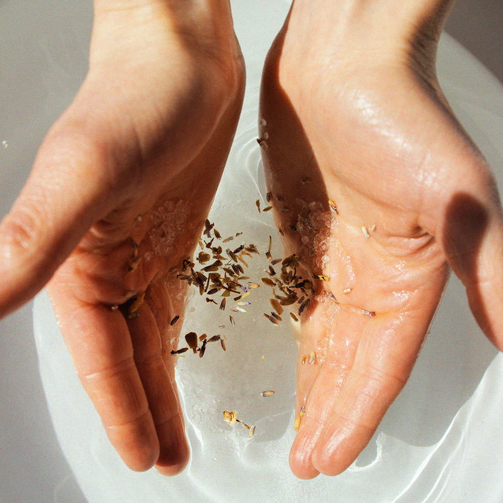 BJÖRK & BERRIES Birch Ritual Bath Salt / Badesalz. Hands spreading bath salt.