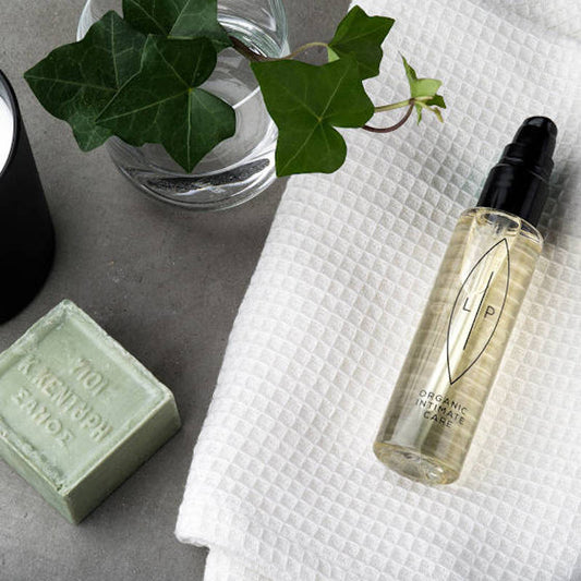 Lip Organic Intimate Care. Ölbasierte Produkte für den Intimbereich. Flasche auf einem Handuch. 